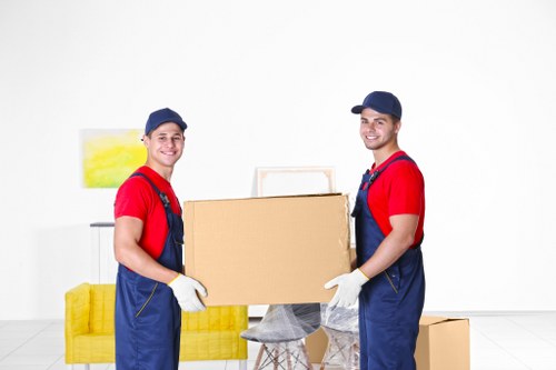 Students moving boxes and furniture in Harrow with a local removals van