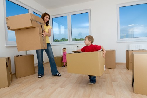 Removal staff carrying desks and office items through a workplace corridor
